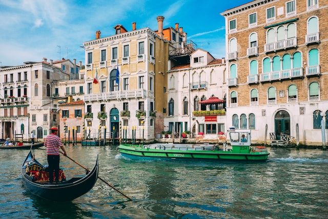 do a gondola ride in the grand canal beneath rialto bridge (Daniel Corneschi on Unsplash)