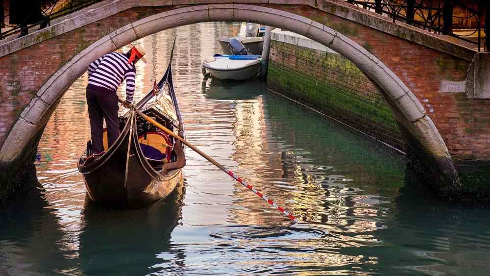 striped shirt - closed dark shoes - banded straw hat gondolier rows (Ramon Perucho da Pixabay )